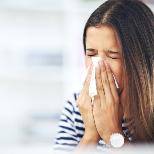 Mujer con alergia se suena con un pañuelo